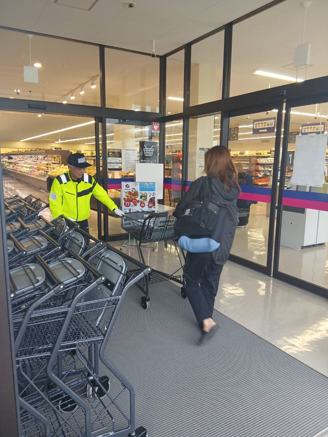 店舗入口で来店者を案内する警備員